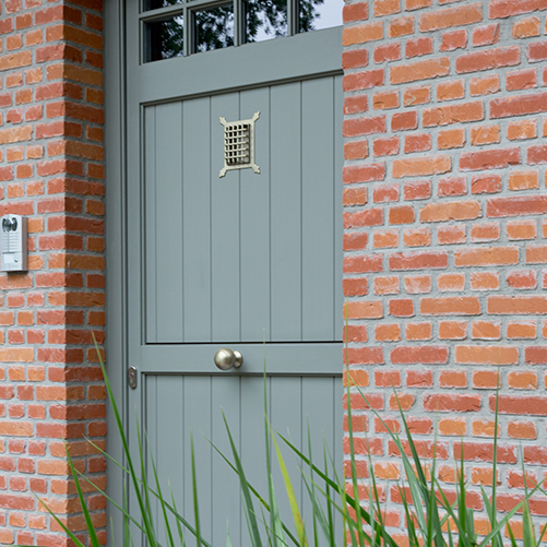 Porte en bois avec poignet et judas installée par Châssis Williams